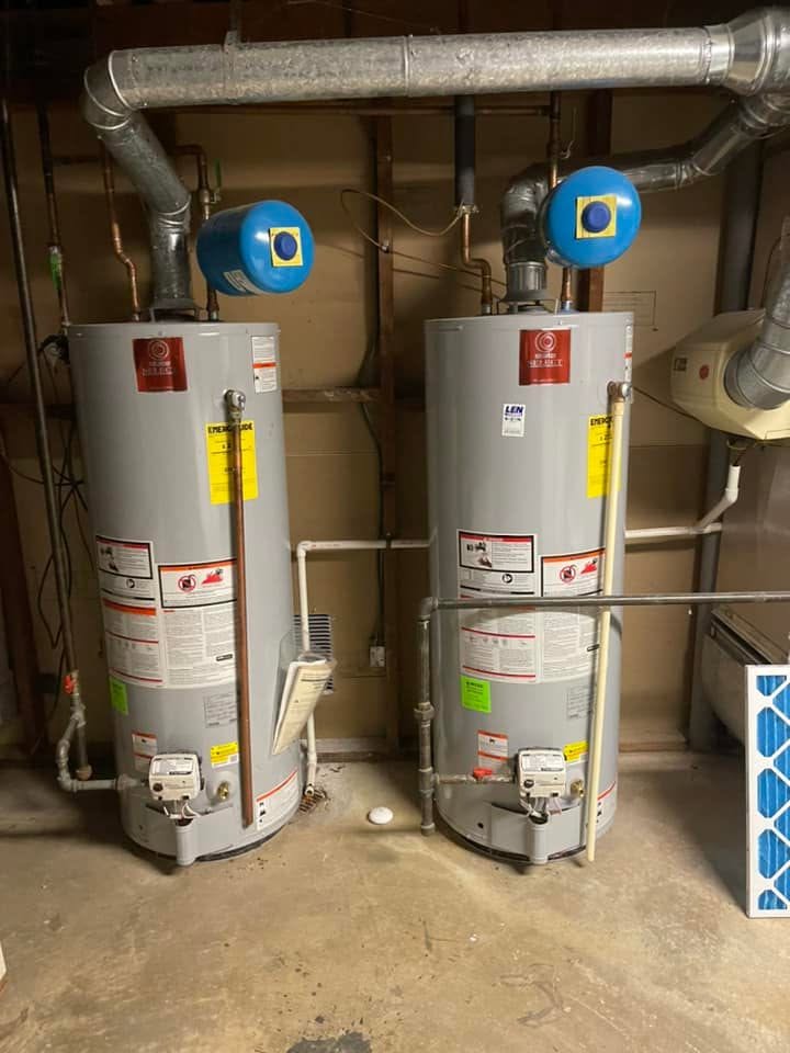 Two newly installed gas water heaters with expansion tanks in a Maryland basement