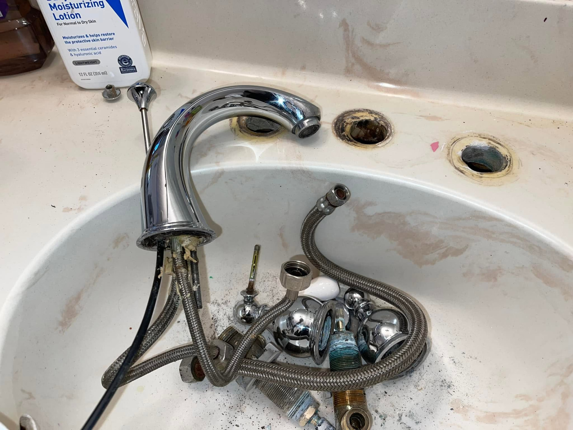Old bathroom faucet and supply lines removed from a vanity sink