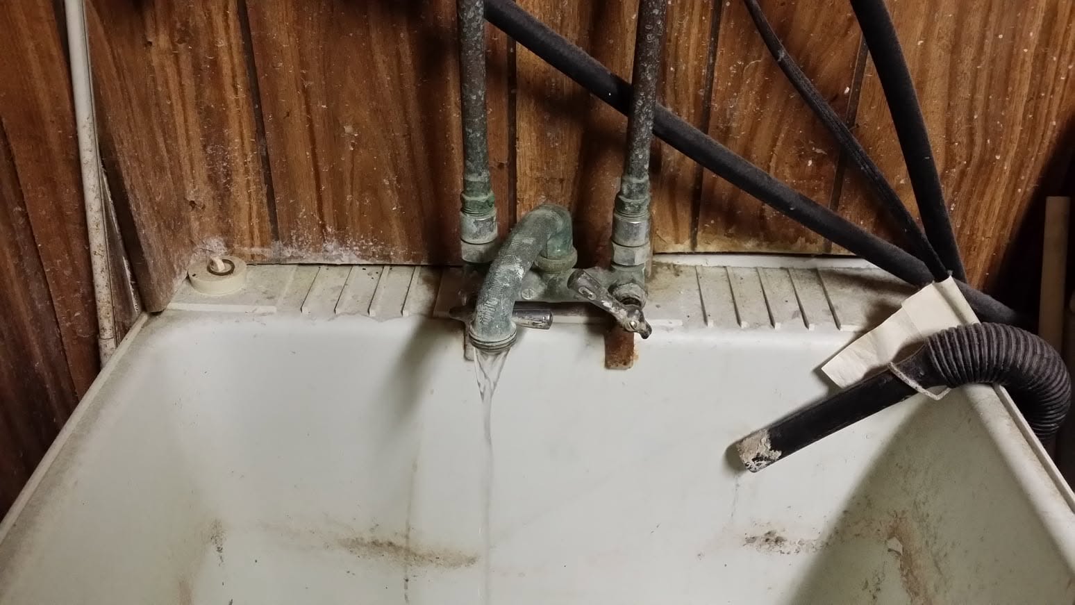 Corroded laundry sink faucet and old galvanized supply lines before repair