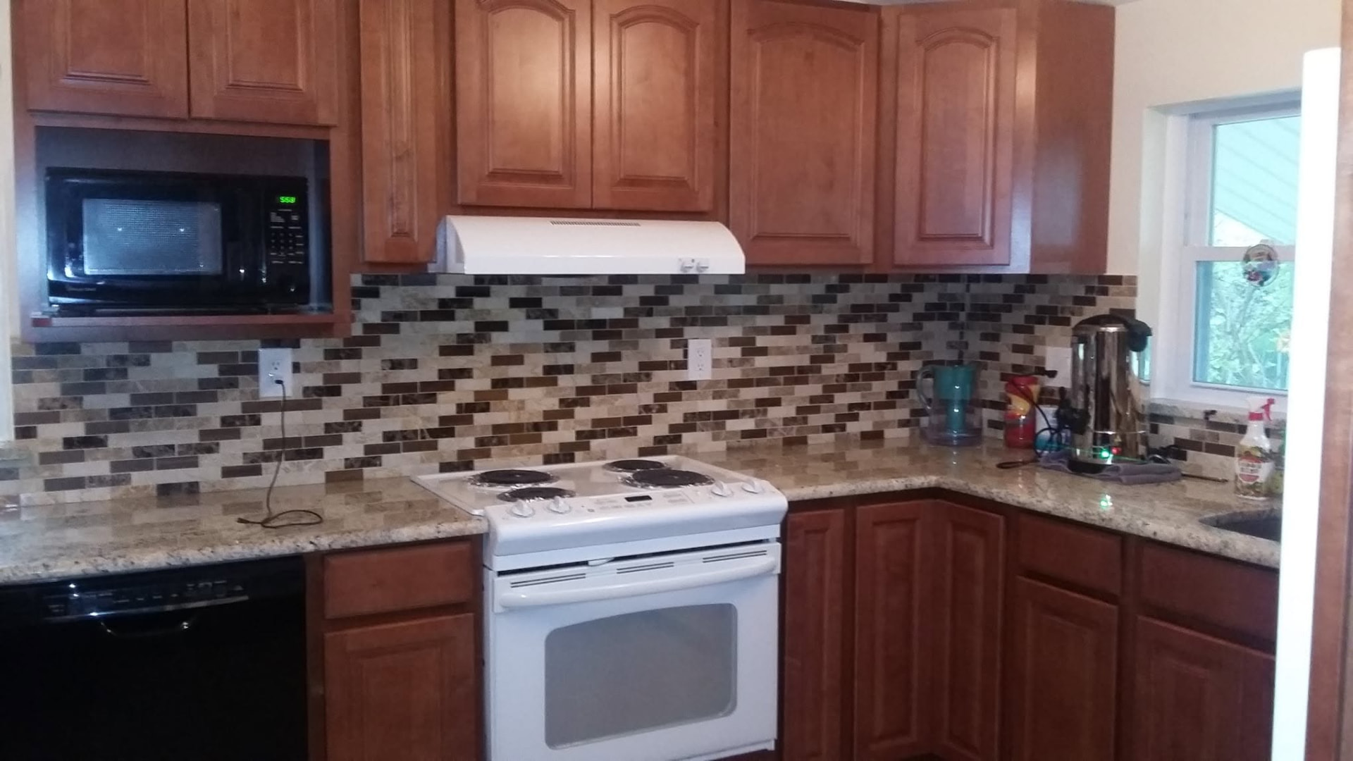 Real Services Squad kitchen project with mosaic tile backsplash and granite countertops